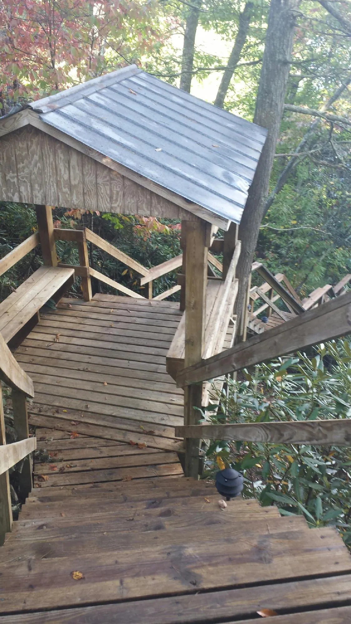 Metal roofed shelter over wooden steps on a wooded walkway — Skylight Repair & Installation work by our crew in Jamaica Plain