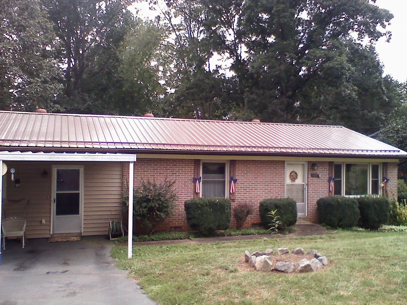 Bronze metal roof and carport on a brick ranch home — Roof Repair work by our crew in Jamaica Plain