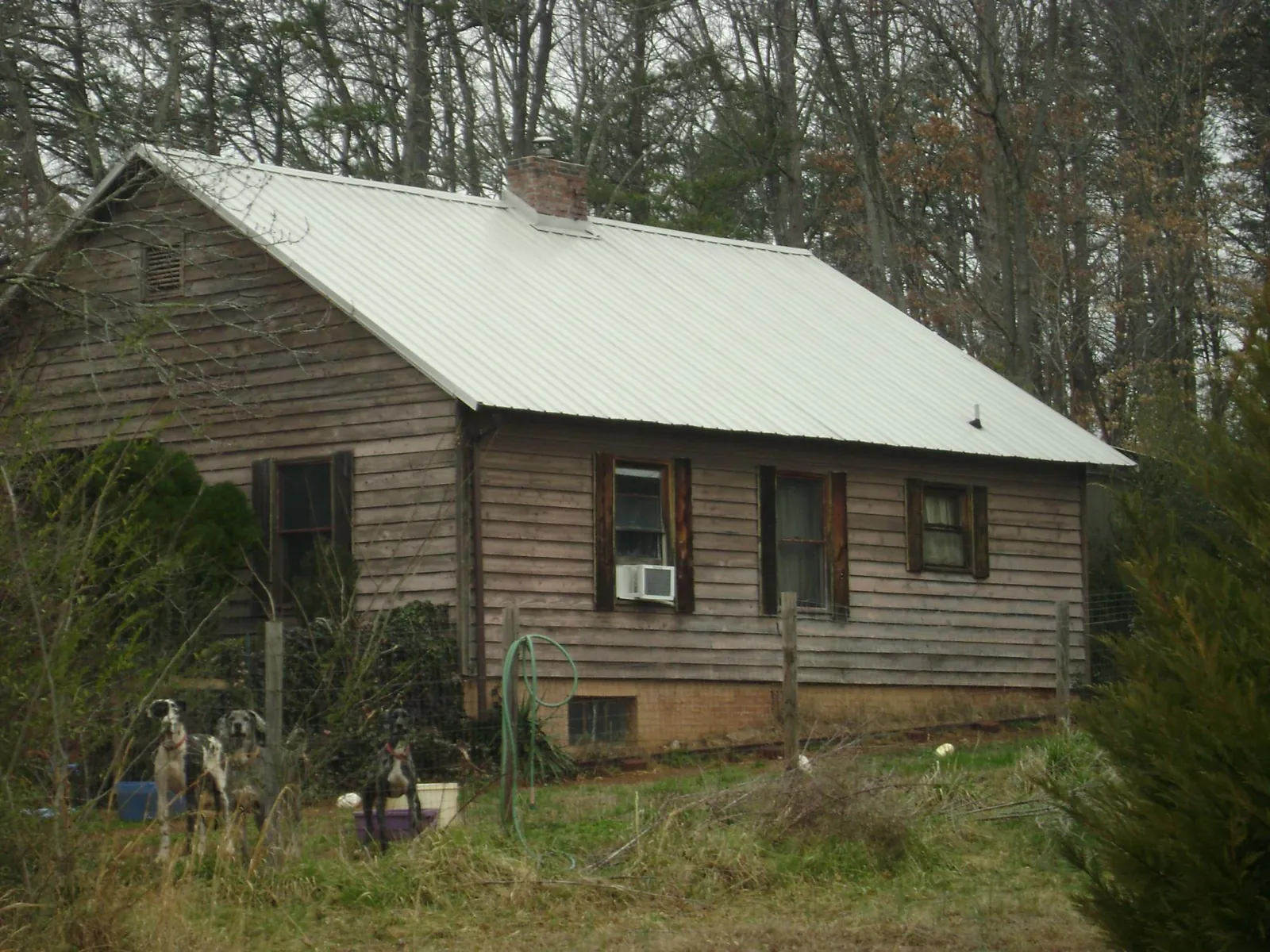 White metal roof on an old wood sided farmhouse, from a Metal Roof Installation job in Jamaica Plain